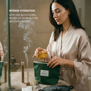 Woman in a robe holding a green bag with a product, surrounded by incense and a diffuser.